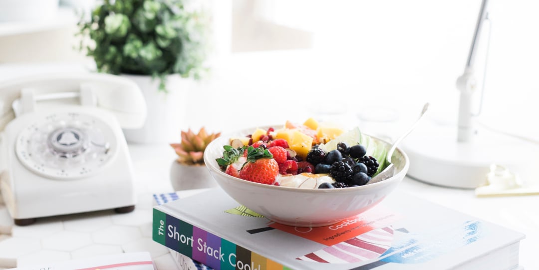 Image of sun-filled room with a bowl of cereal and fresh fruit