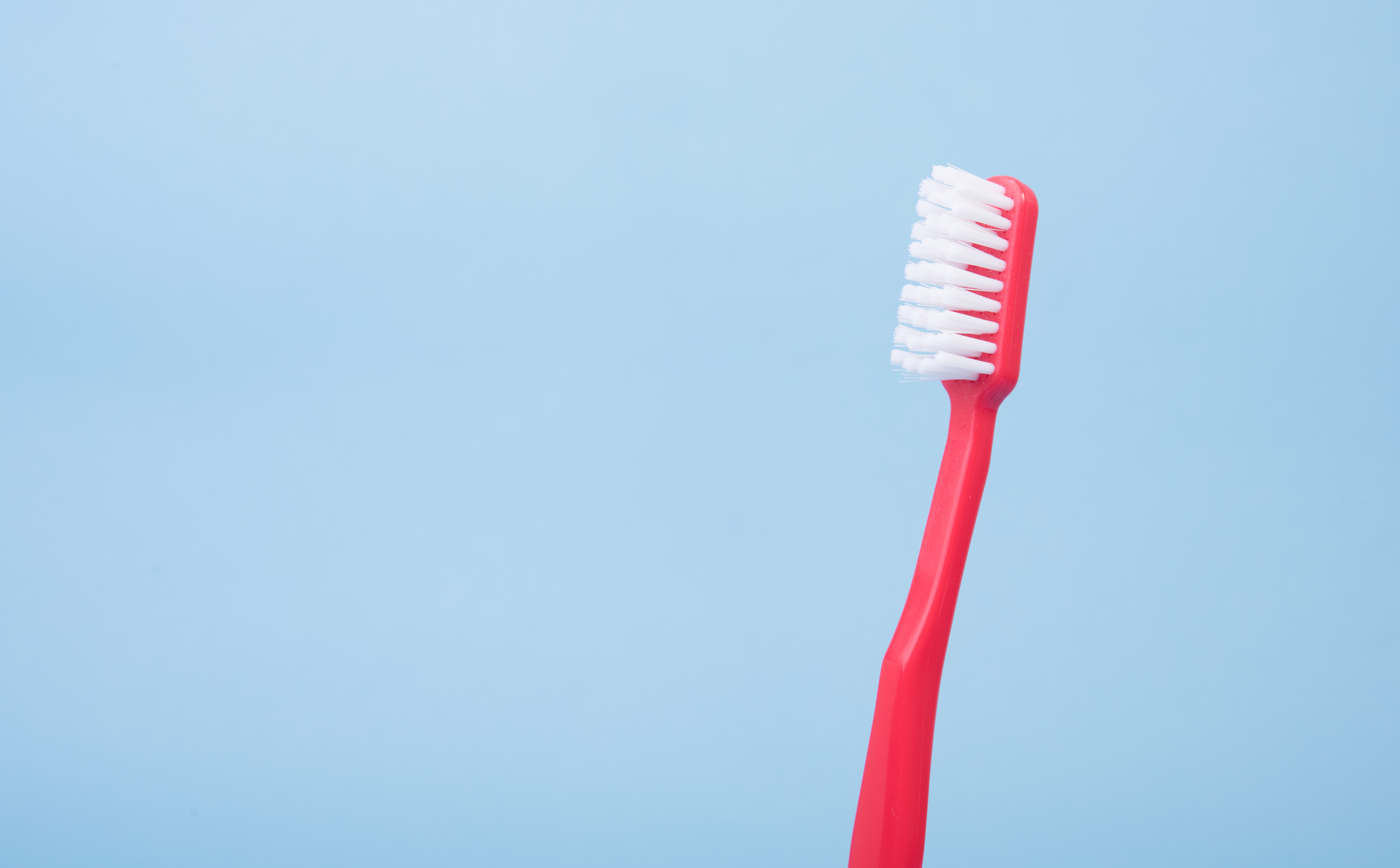 red toothbrush against blue background