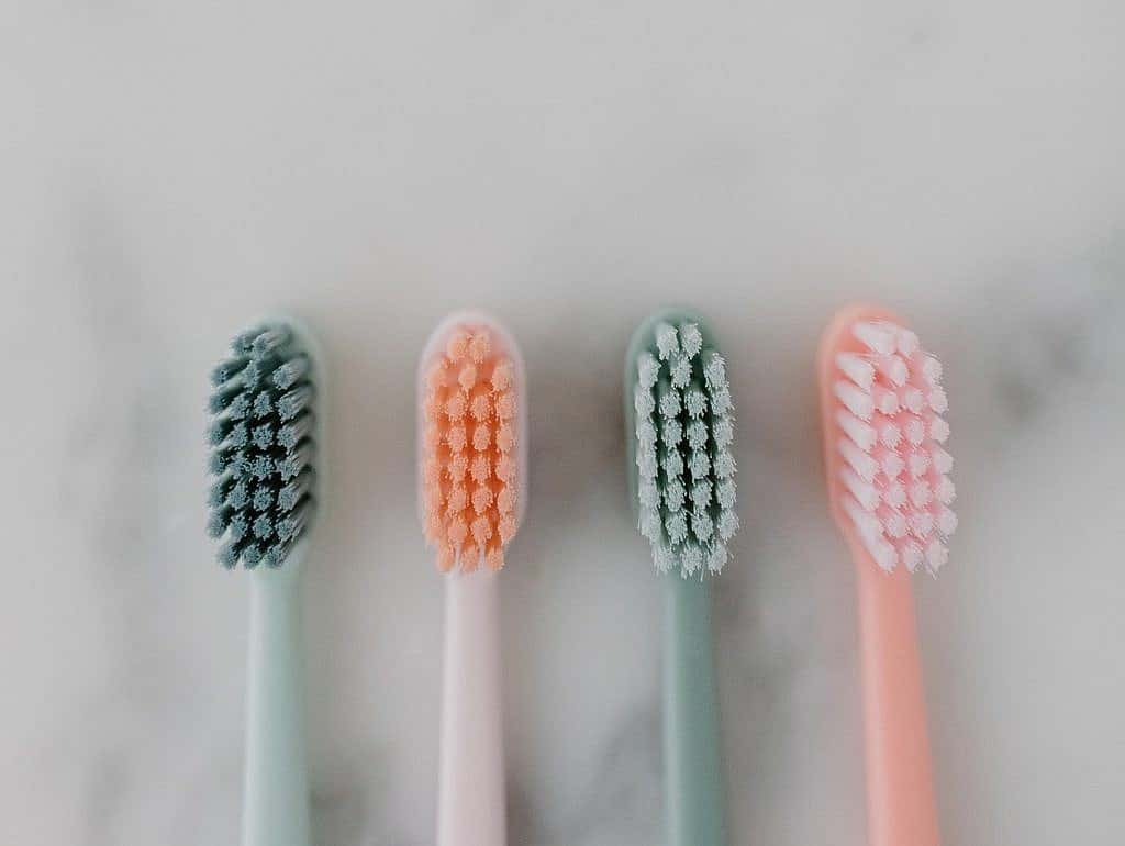 pastel colored toothbrushes in a row