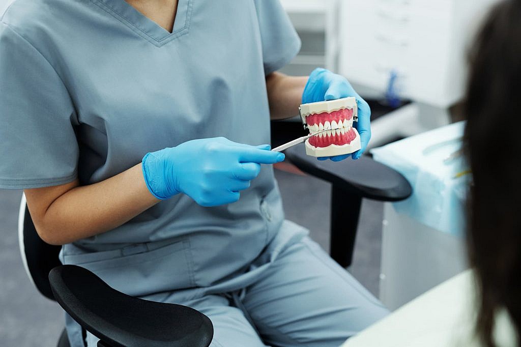 dental hygienist holding up a mouth model